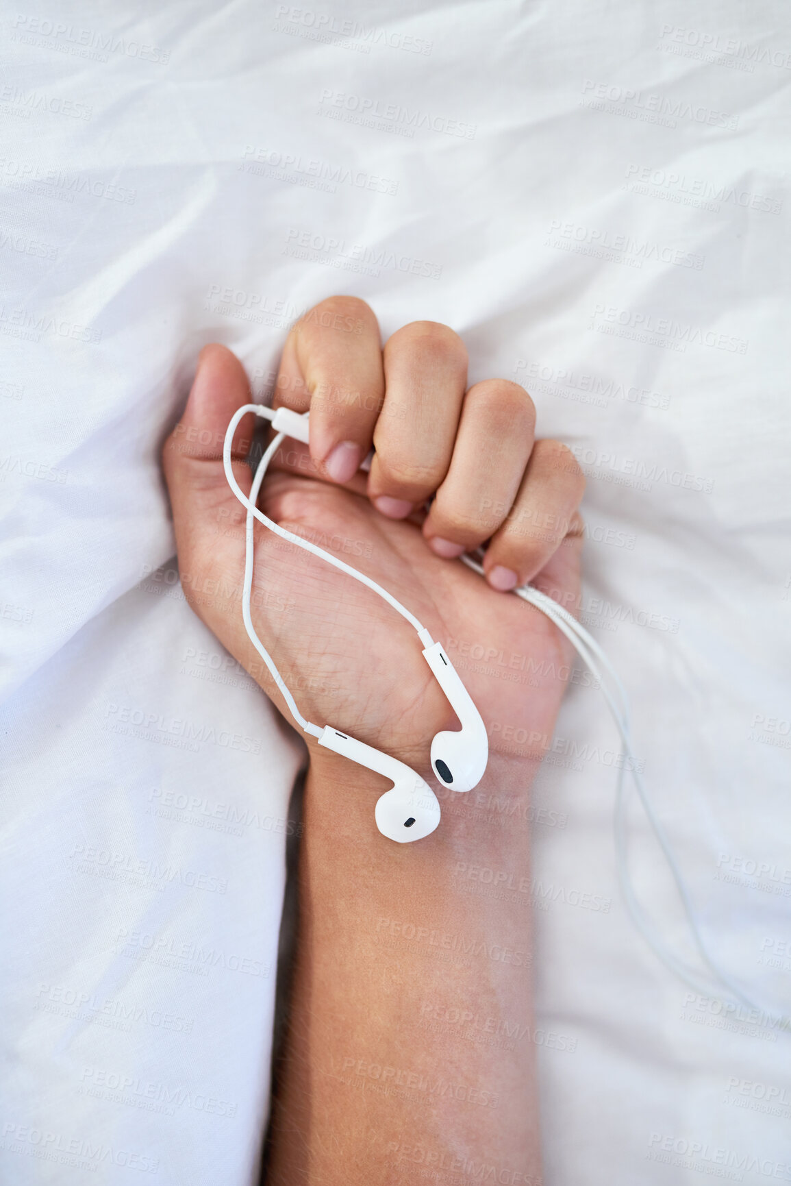 Buy stock photo Hands, person and bed with holding earphones for music, audio for healing body, soul and mind. Volume, sound and radio on break in bedroom at home to relax, chill and rest for mindfulness and care