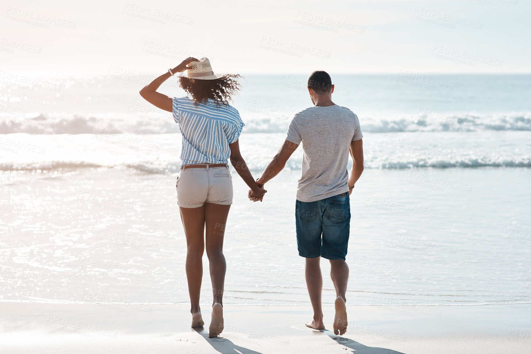 Buy stock photo Walk, back and holding hands with couple love, beach and happy relationship for anniversary on holiday together. Romance, African man and woman for ocean, break and bonding with sunset on vacation