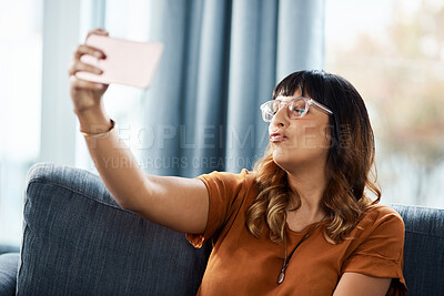 Buy stock photo Woman, home and funny face on sofa for selfie on break for social media post, interaction and profile picture. Female person, eyes closed and couch in living room for content creation and photo album