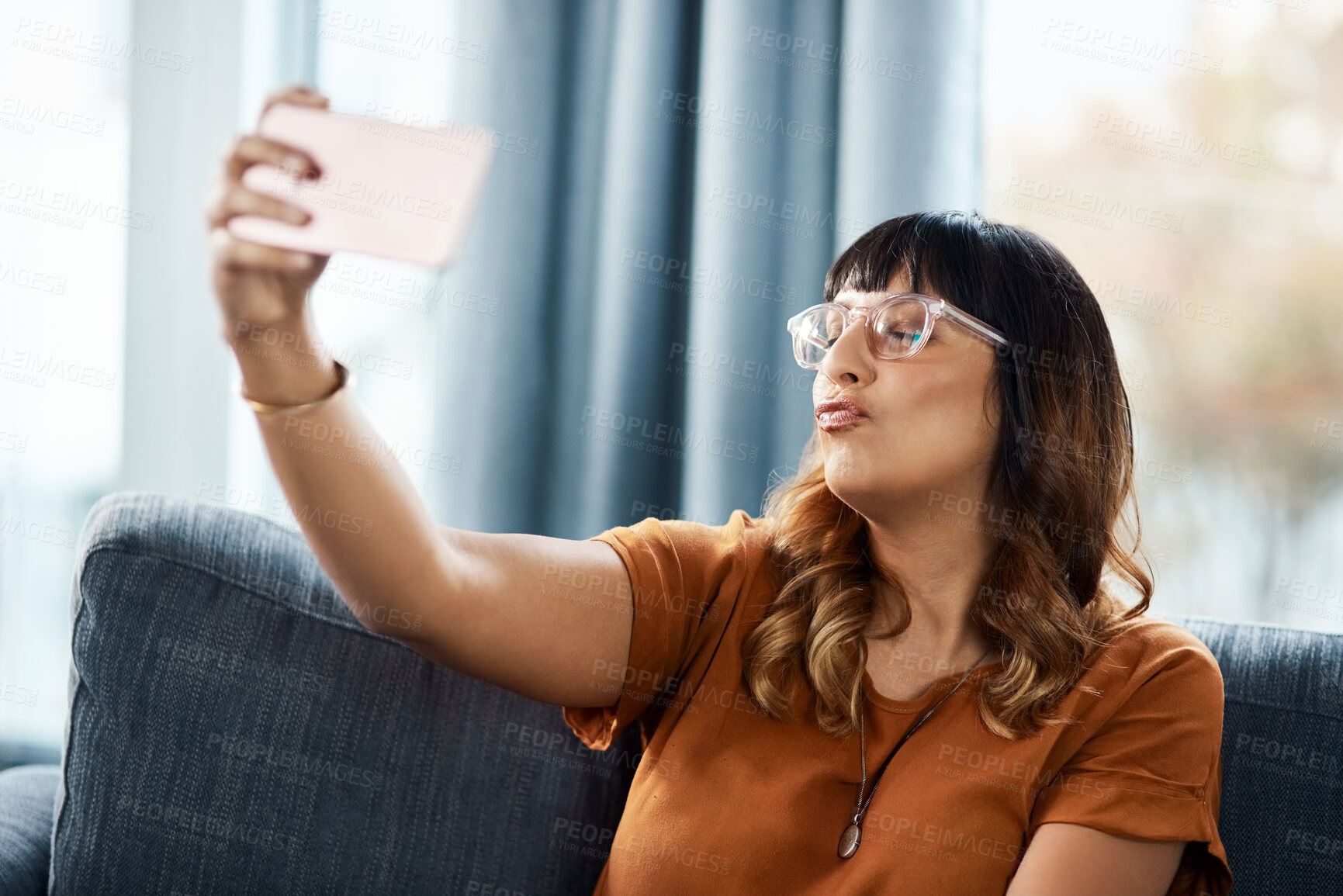 Buy stock photo Woman, home and funny face on sofa for selfie on break for social media post, interaction and profile picture. Female person, eyes closed and couch in living room for content creation and photo album