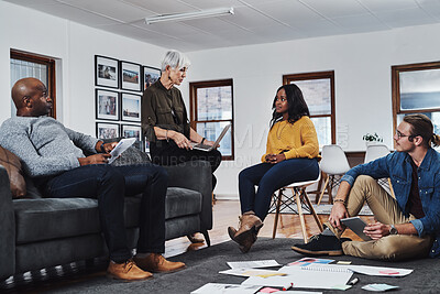 Buy stock photo Shot of a group of businesspeople having a meeting and discussing ideas in their office at work