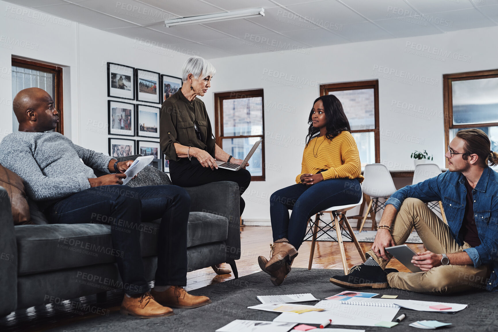 Buy stock photo Shot of a group of businesspeople having a meeting and discussing ideas in their office at work