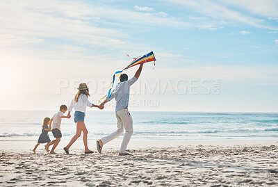 Buy stock photo Family, flying kite and holding hands on beach together for holiday, travel or vacation in summer. Energy, love or running with mother, father and kids on sand at coast by ocean or sea for bonding