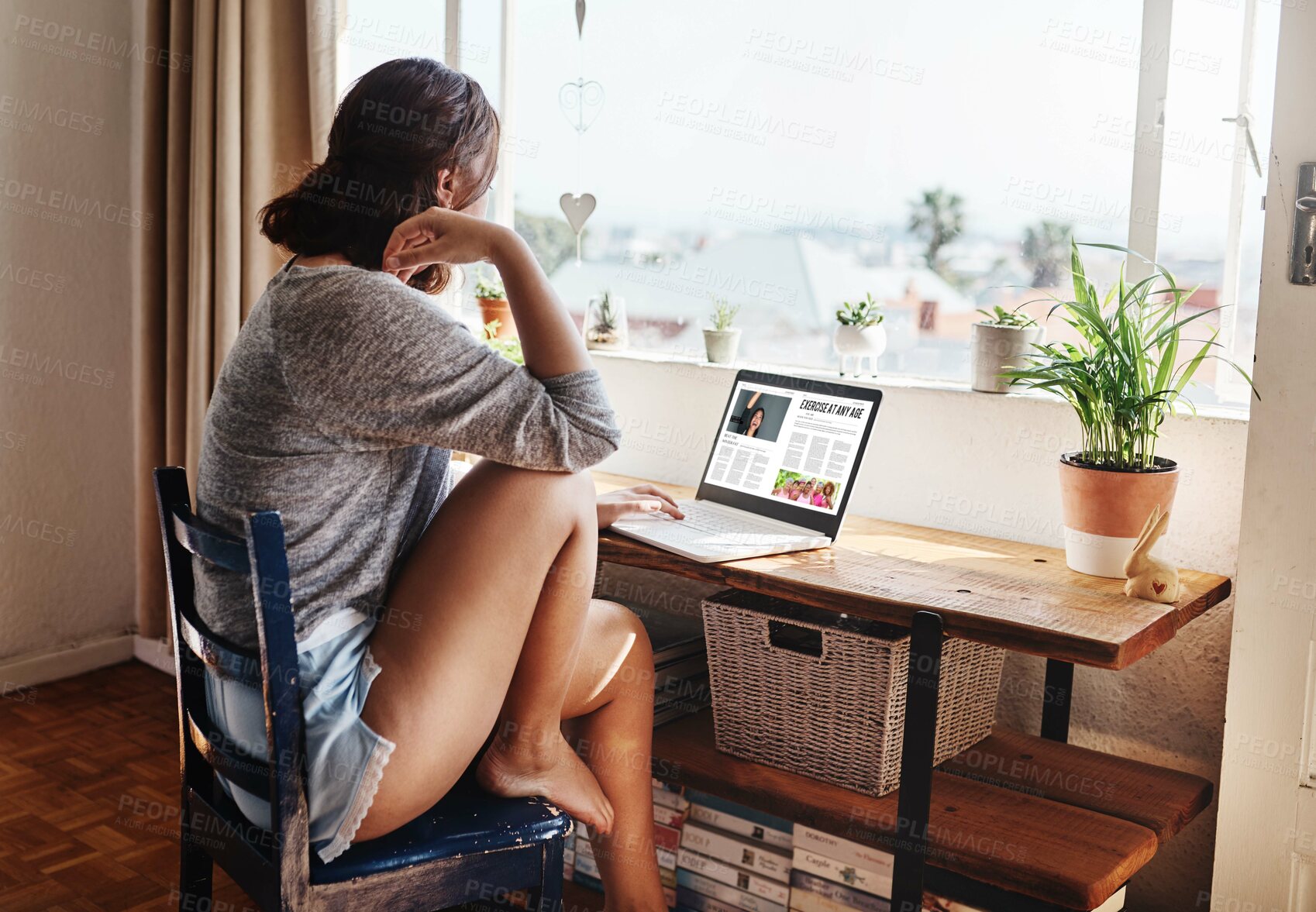 Buy stock photo Woman, reading and laptop with screen in home for thinking, barefoot or back with exercise blog in morning. Person, pc and browsing with research on web for training, workout or wellness at apartment