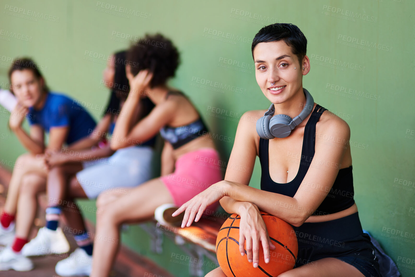 Buy stock photo Portrait of a sporty young woman taking a break with her friends after a game of basketball