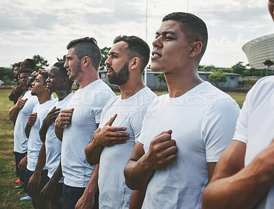 Buy stock photo Cropped shot of a team of confident young rugby players standing at attention singing their anthem outside on a field before a rugby match