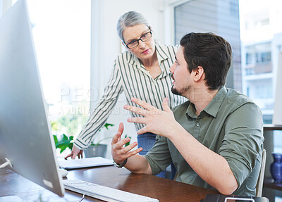 Buy stock photo Shot of two businesspeople working together on a computer in an office