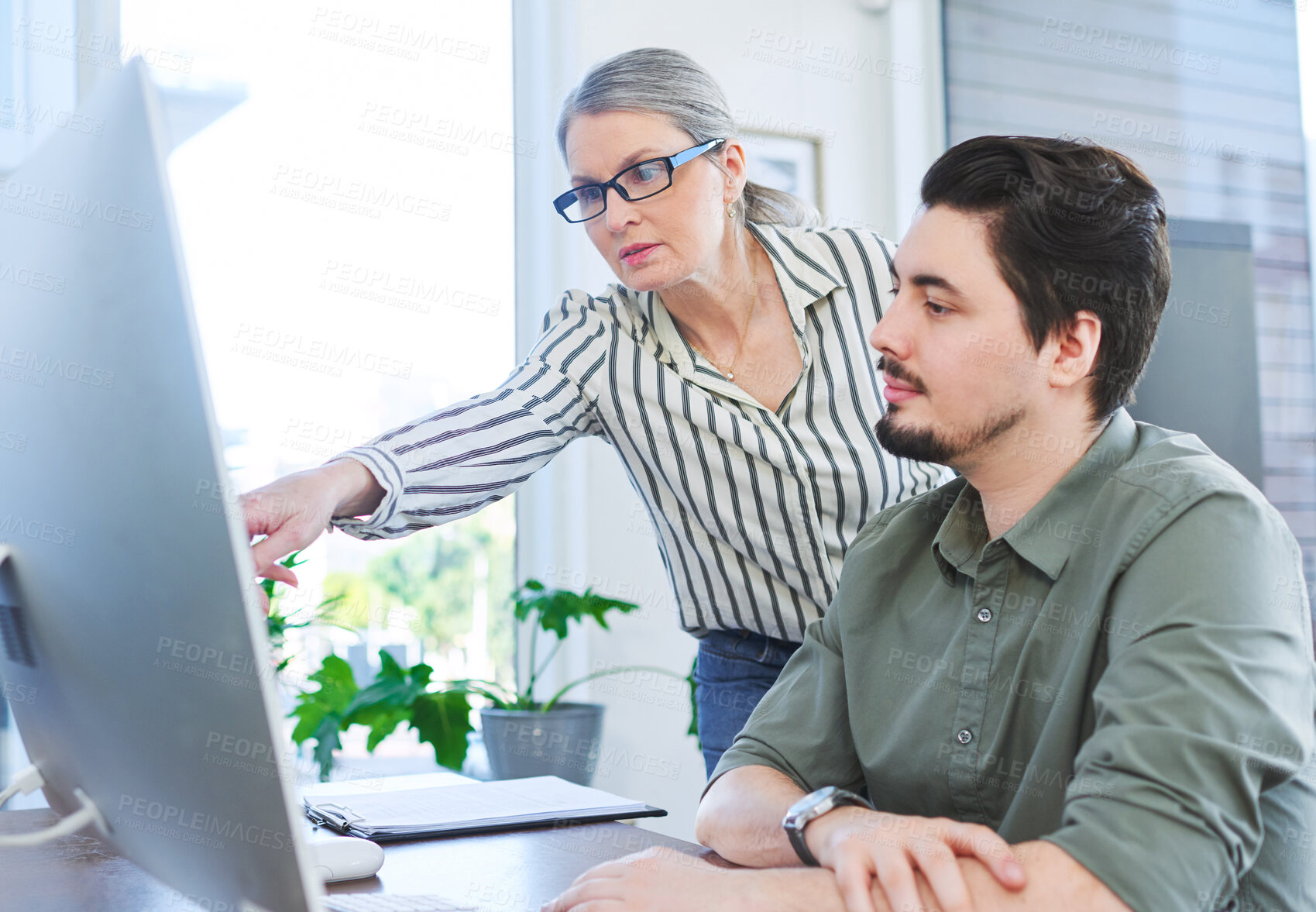 Buy stock photo Shot of two businesspeople working together on a computer in an office