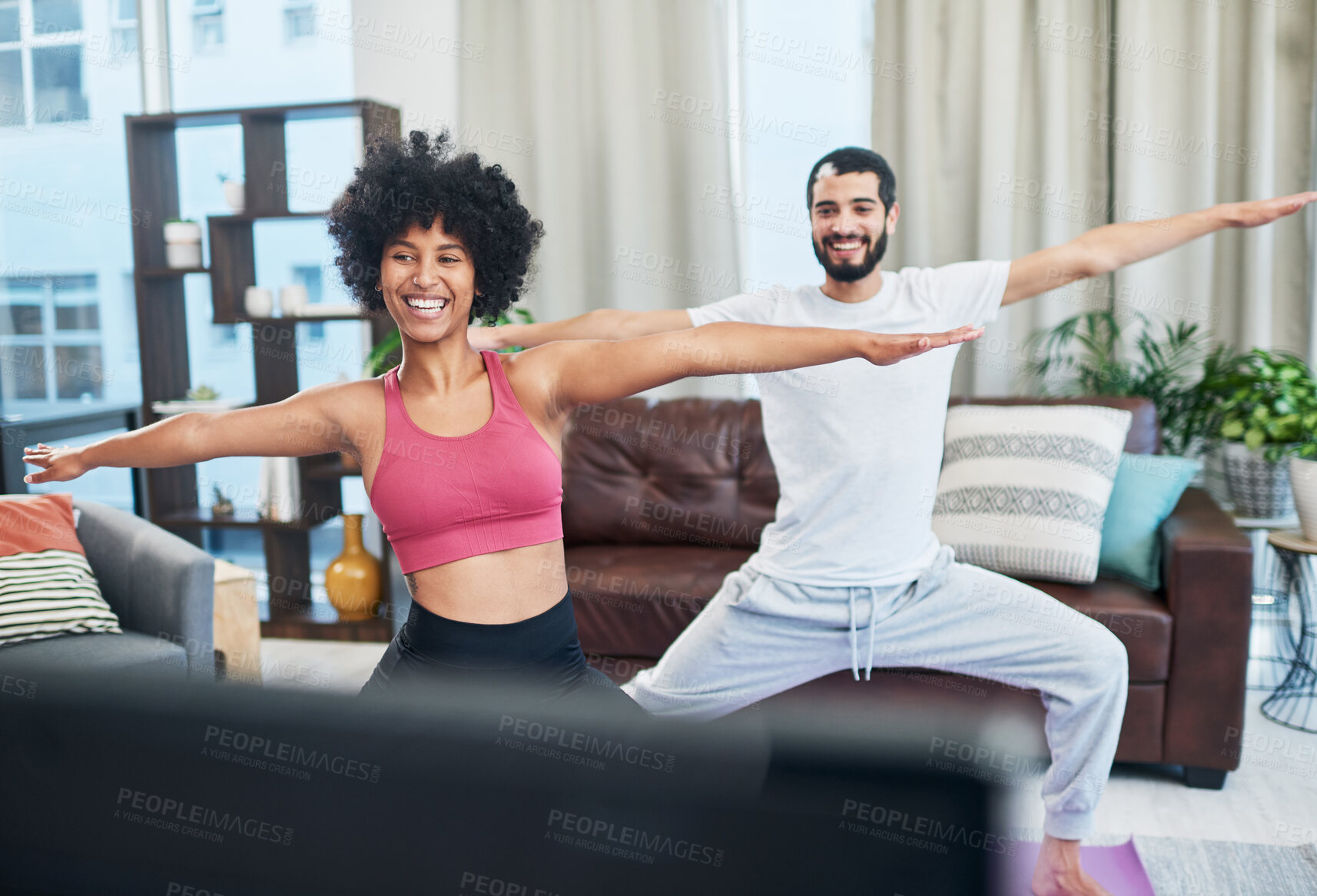 Buy stock photo Shot of a couple looking at the television while practising yoga at home