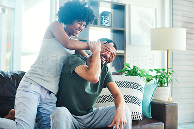 Buy stock photo Shot of a woman covering her boyfriend's eyes while sitting on a couch