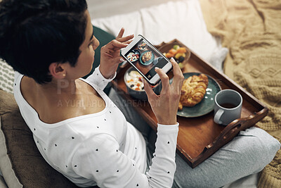 Buy stock photo Shot of a young woman taking a picture of her  breakfast in bed at home