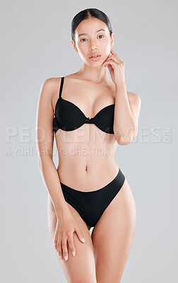 Buy stock photo Shot of an attractive young woman standing and posing in her underwear in the studio