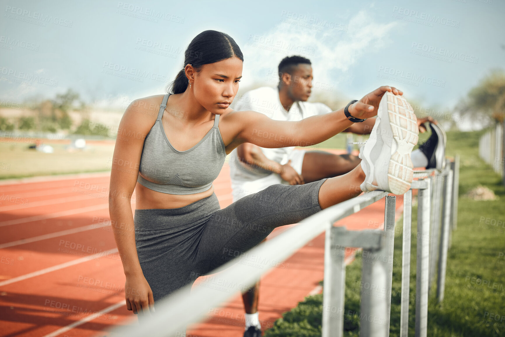 Buy stock photo Cropped shot of a young athletic couple warming up before starting their outdoor exercise routine