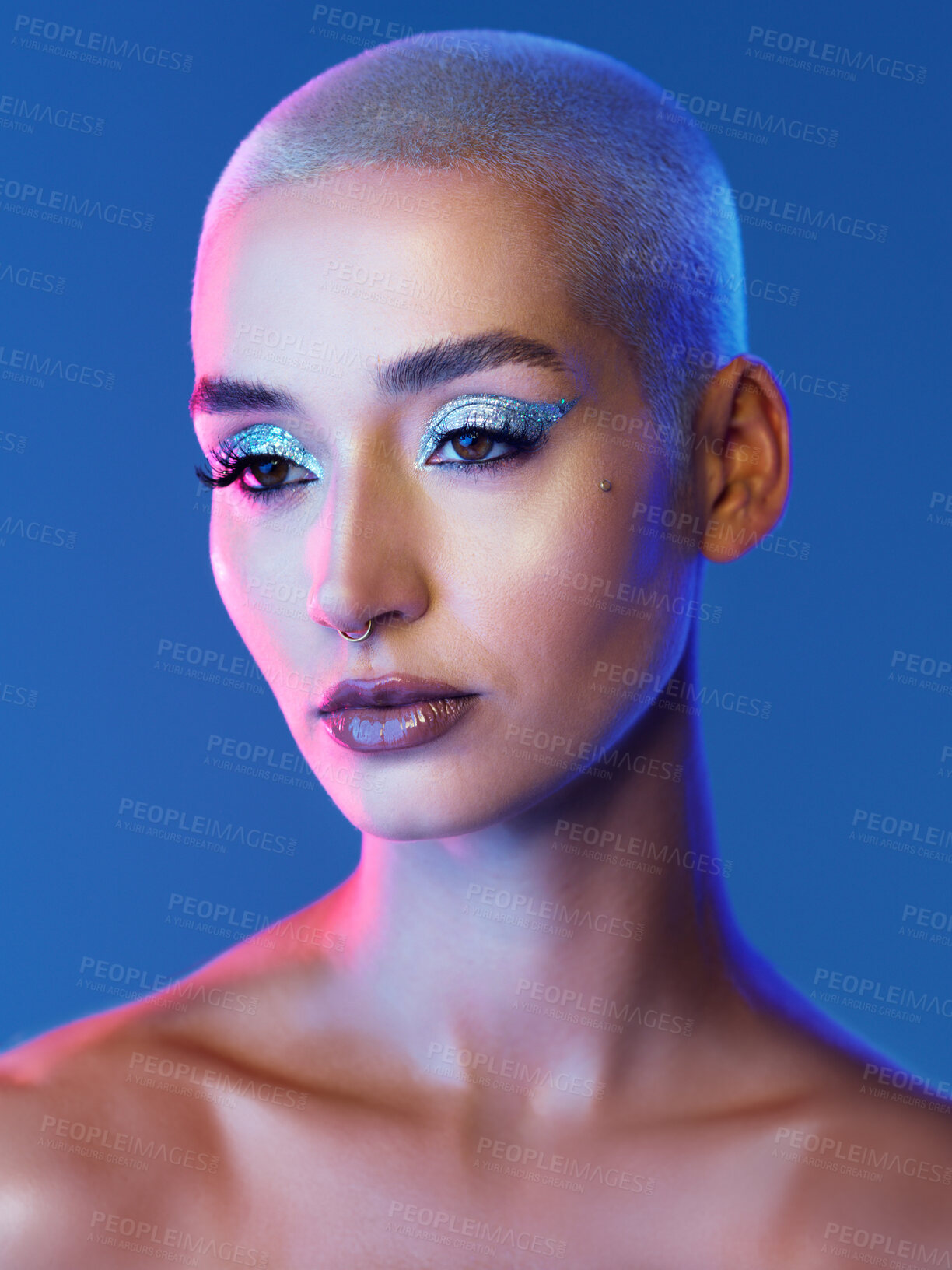 Buy stock photo Studio shot of an attractive young woman wearing edgy makeup against a blue background