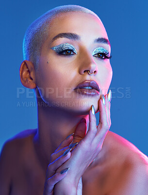 Buy stock photo Studio shot of an attractive young woman wearing edgy makeup against a blue background