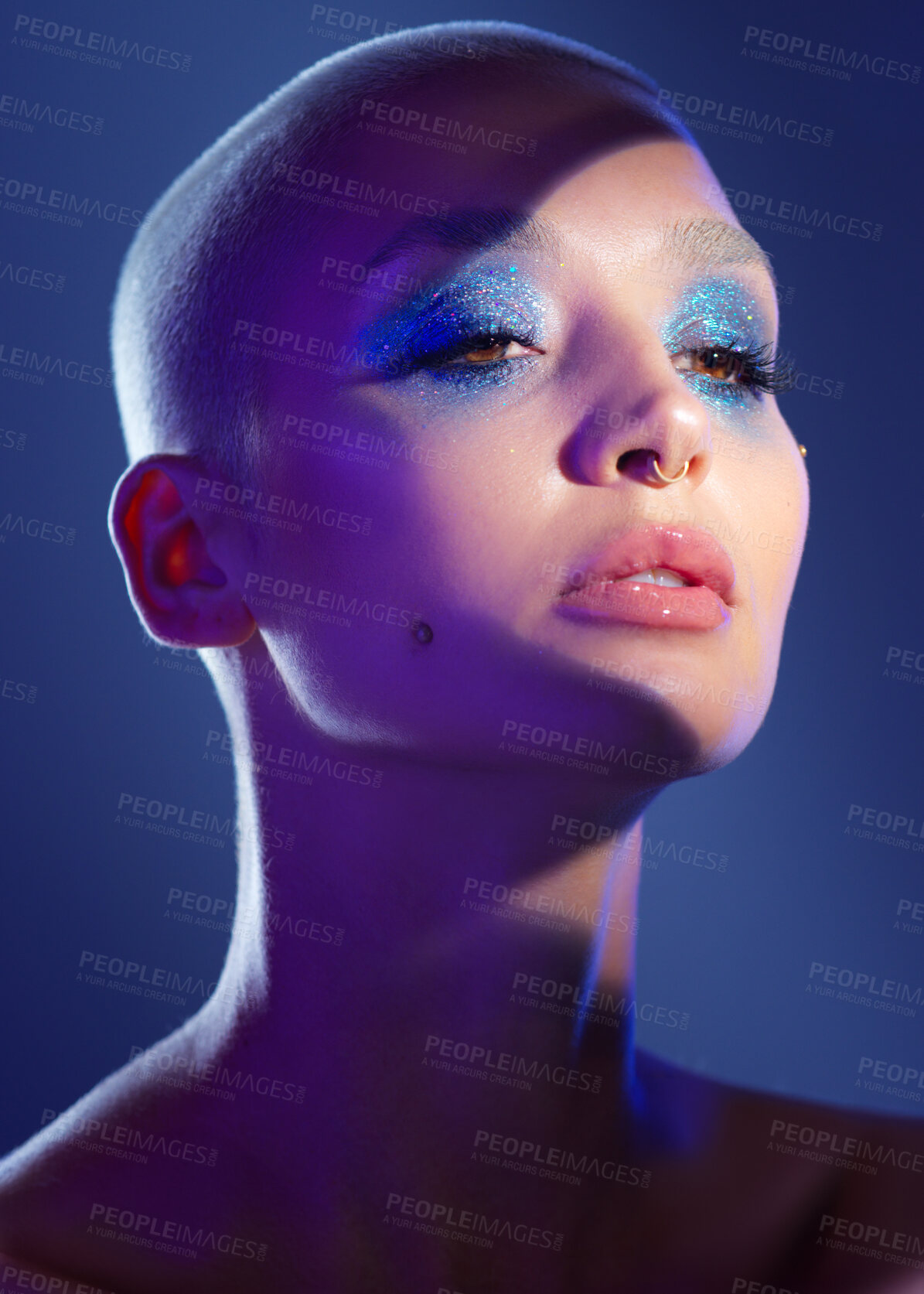 Buy stock photo Studio shot of an attractive young woman wearing edgy makeup against a blue background