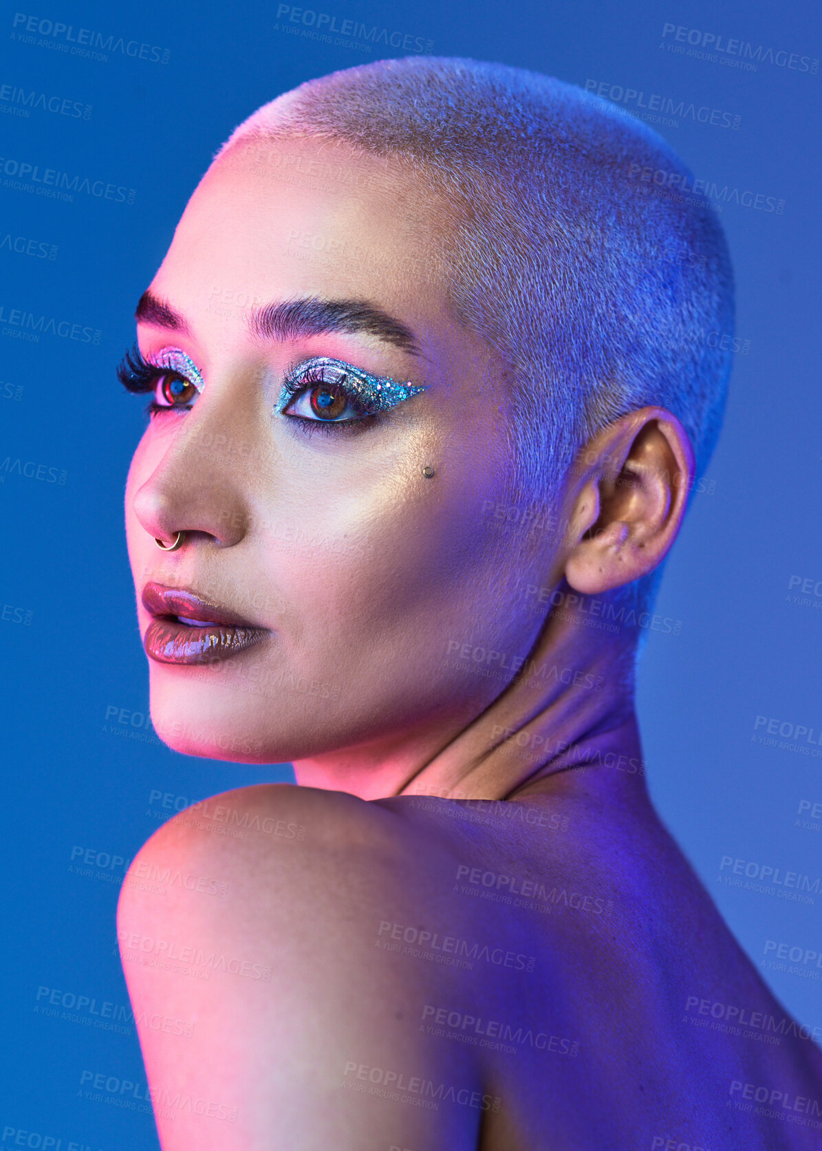 Buy stock photo Studio shot of an attractive young woman wearing edgy makeup against a blue background