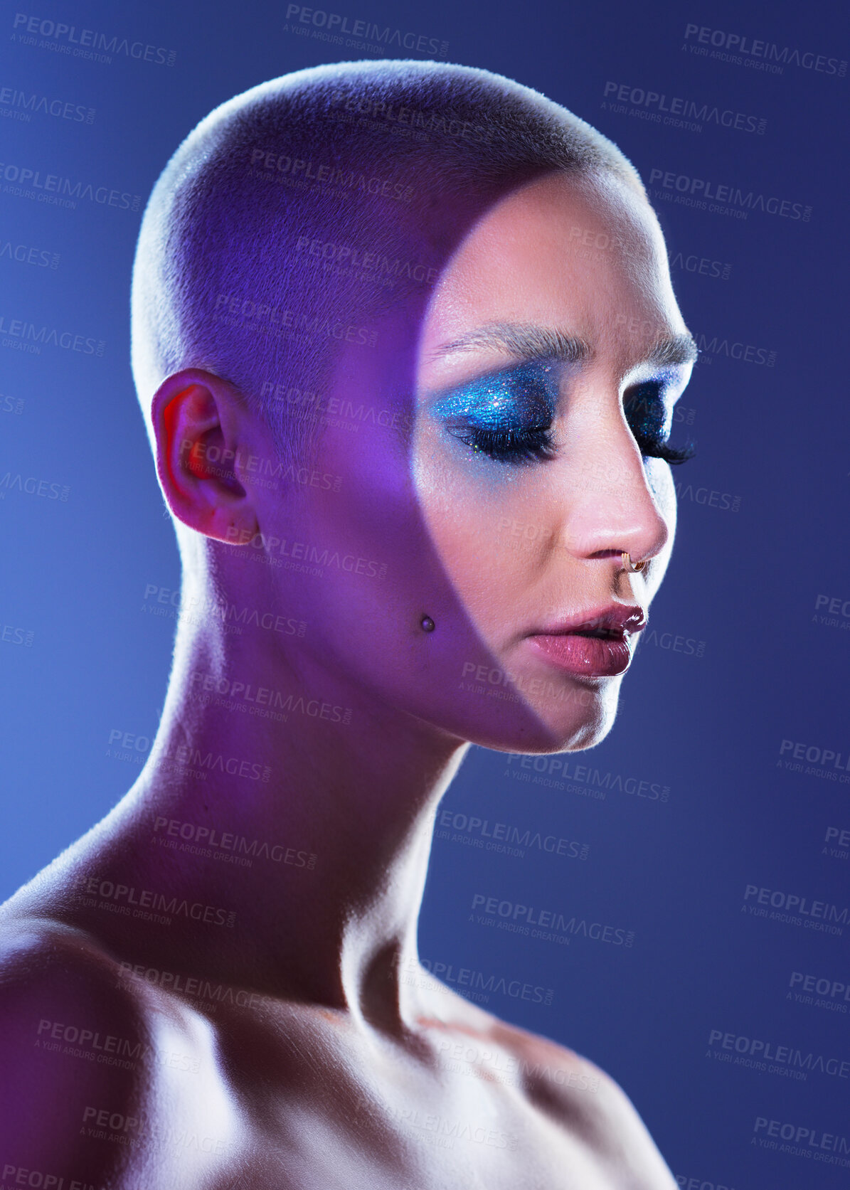 Buy stock photo Studio shot of an attractive young woman wearing edgy makeup against a blue background