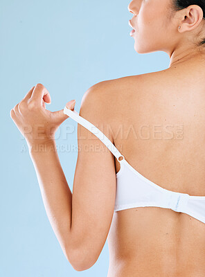 Buy stock photo Rearview shot of a young woman posing against a blue background