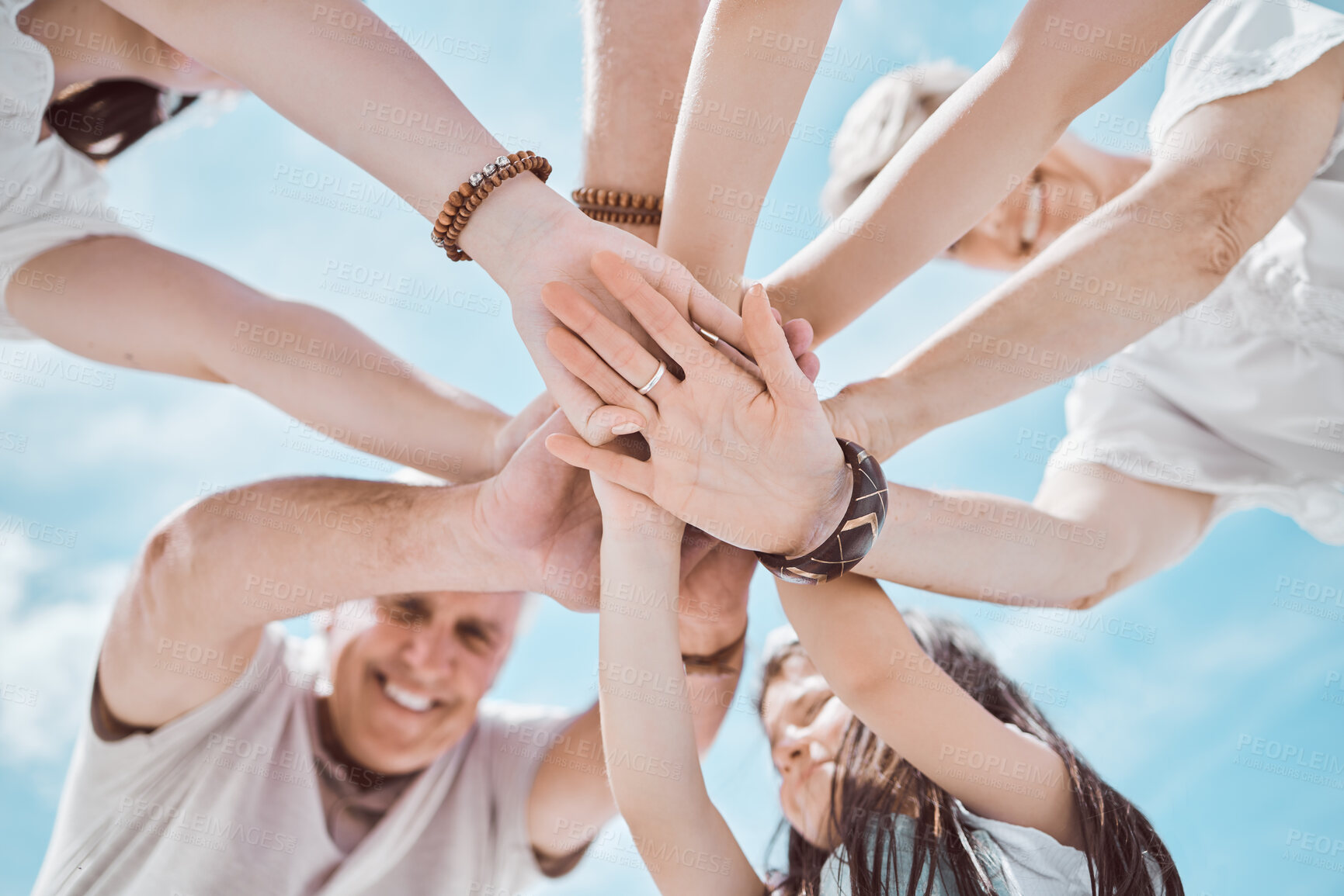 Buy stock photo Family, hands and stack outdoor for support, solidarity and bonding together with blue sky and love. People, low angle and travel outside for teamwork, collaboration and connection with group circle