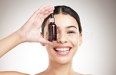 Buy stock photo Portrait, woman and bottle for skincare in studio with facial serum, collagen treatment and dermatology glow. Smile, girl and essential oil for aesthetic, beauty or hyaluronic acid on gray background