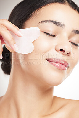 Buy stock photo Face, skincare and gua sha with woman in studio for cosmetics, collagen and facial. Self care, glow and shine with model and rose quartz on white background for beauty, lymphatic drainage and massage