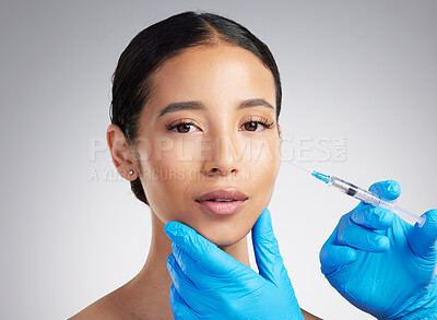 Buy stock photo Studio portrait of a gorgeous mixed race woman getting derma filler. Hispanic model getting cosmetic surgery against a grey copyspace background