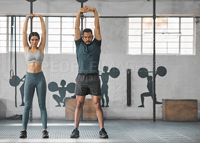 Buy stock photo Fitness, active and healthy couple stretching, exercising or training together inside gym. Two young fit trainer doing a full body workout exercise or warmup routine in the day time with copy space