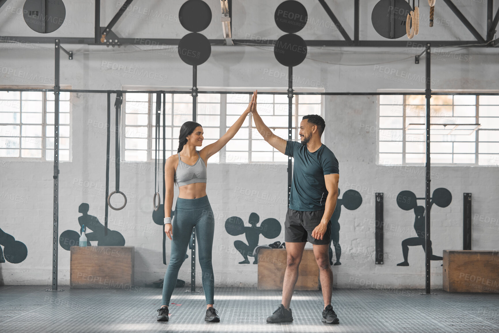 Buy stock photo Fit, active and healthy sports athletes training together in gym workout room, living a strong wellness lifestyle. Male and female fitness instructors high five and smiles in physical exercise class