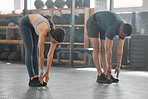 Fit, active and strong couple doing a warmup and stretching before a workout at the gym. Sporty boyfriend and girlfriend doing stretches to avoid injury, soreness and painful muscles during exercise