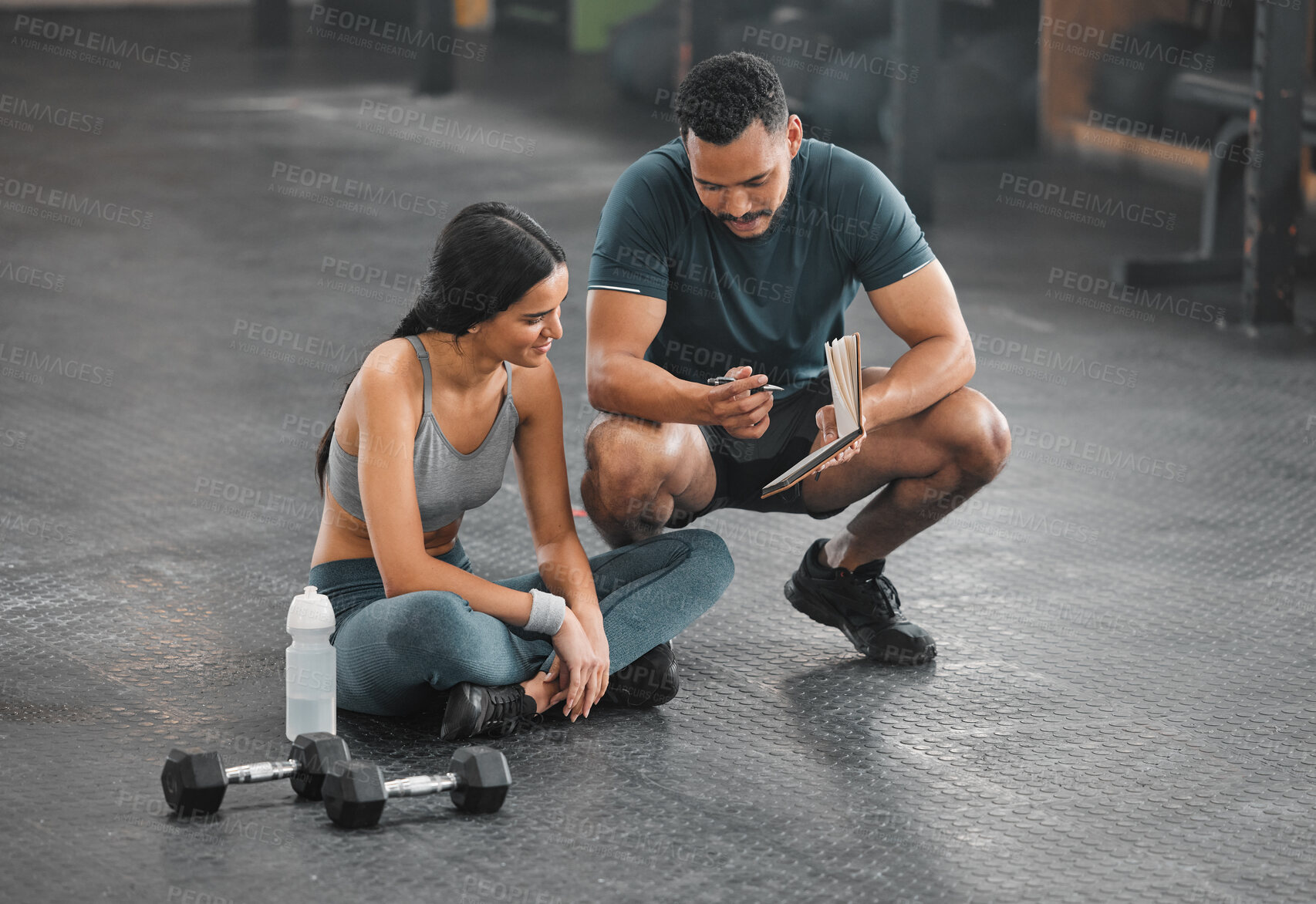 Buy stock photo Personal trainer, coach or fitness instructor helping an active and fit woman in the gym. Young female athlete sitting down and managing her workout routine or schedule with her exercising partner