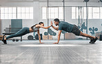 Fitness partners exercising together and doing pushups high five at the gym. Fit and active man and woman training in a health facility as part of their workout routine. A couple doing an exercise