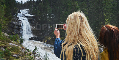 Buy stock photo Woman, friends and camera with waterfall for sightseeing, picture or photography in nature. Female person, tourist or traveler with phone screen for memory, view or adventure by river in forest