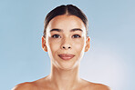 Closeup face beautiful young mixed race woman. An attractive female posing in studio isolated against a blue background. A skincare regime that keeps your skin soft, smooth, glowing and healthy