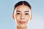 Closeup face beautiful young mixed race woman. An attractive female posing in studio isolated against a blue background. A skincare regime that keeps your skin soft, smooth, glowing and healthy