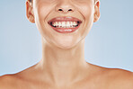 Closeup face beautiful young mixed race woman. Attractive female smiling in studio isolated against a blue background. Practising good oral and dental hygiene for healthy mouth, teeth and gums