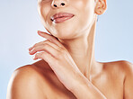 Closeup face beautiful young mixed race woman. Attractive female touching her face in studio isolated against a blue background. A skincare regime to keep your skin soft, smooth, glowing and healthy