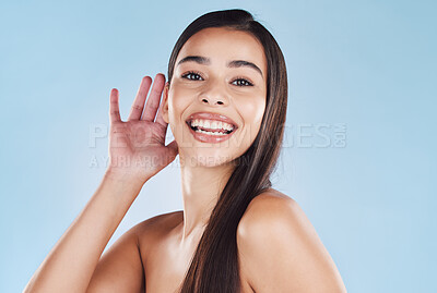 Buy stock photo Woman, hairstyle and hand by ear in studio with cosmetics for gossip, listen and sign by blue background. Model, girl and person with hair care, smile and portrait with results for beauty in Colombia