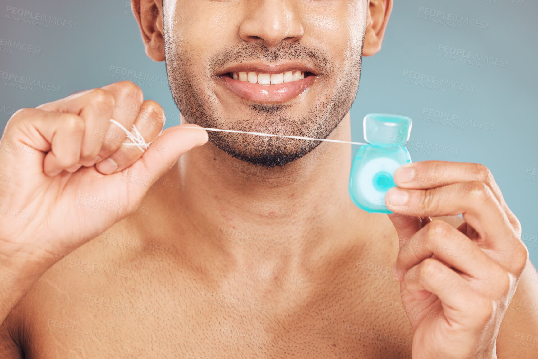 Buy stock photo Studio, closeup and man with dental floss for wellness, gum hygiene and health with cleaning for fresh breath. Male model, teeth and string by blue background for mouth, gingivitis and oral care