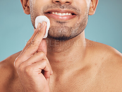 Buy stock photo Studio, hand and man with cotton for skincare, hygiene health and wellness with self care for grooming. Smile, male model and cleaning with cosmetics by blue background, swab pad and facial treatment