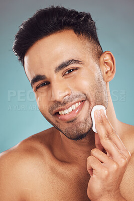 Buy stock photo Man, cotton pad and studio portrait for skincare with hygiene, cleaning and grooming by blue background. Person, model and beard with smile for dermatology, wellness and cosmetics for transformation