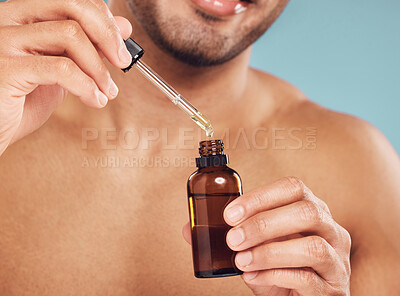 Buy stock photo Skincare, hands and man with serum in bottle, facial treatment product and skin glow on blue background. Cosmetics, retinol liquid and male person with oil, pipette or collagen solution in studio