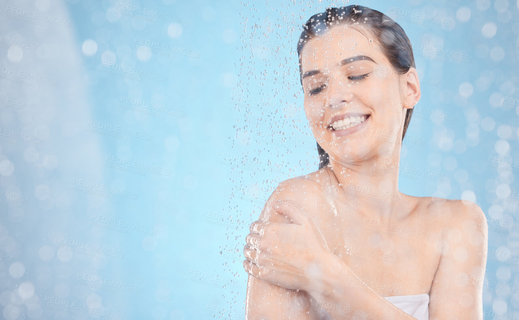 Buy stock photo Beauty, skincare and water drops in shower with a woman washing with soap, cosmetics or dermatology product for clean, soft and healthy skin with glow. Aesthetic model on blue background for hygiene