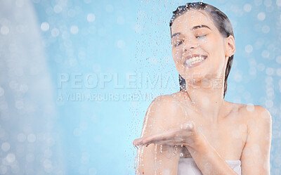 Buy stock photo Water, cleaning and mockup with a woman in the shower in studio on a blue background for hygiene or hydration. Health, skincare and steam with an attractive young female washing in the bathroom