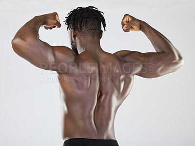 Buy stock photo Back, body and biceps with a model black man posing in studio on a gray background for fitness or exercise. Muscle, health and wellness with a strong male athlete standing or flexing for power