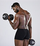 Dumbbell, exercise and fitness of strong black man doing muscle workout in studio. Body of a sexy bodybuilder in underwear training with weights for power, health and wellness or growth motivation