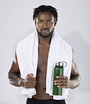 Black man, exercise and portrait with towel and water bottle for sports training in studio. Health and wellness of a sexy male bodybuilder model with bottle for fitness workout, goals and strong body