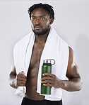 Exercise, fitness and black man with a towel and water for sports training in studio. Health and wellness of a sexy male bodybuilder model thinking about workout, goal and body progress with a bottle