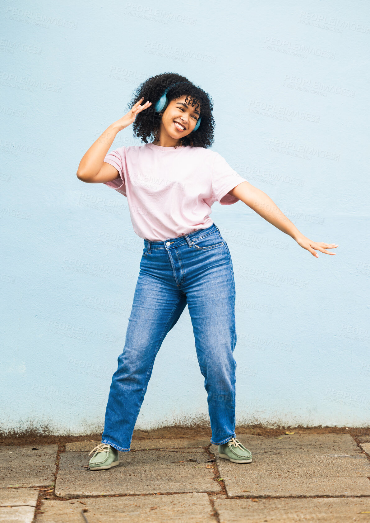 Buy stock photo Black woman, music and dance with headphones on wall background outdoor with energy, freedom and happiness. Happy girl dancing to radio, podcast and sound, hip hop streaming and listening to audio 