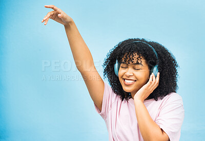 Buy stock photo Dance music, studio mock up and black woman listening to song, audio podcast or radio sound for energy, relief or fun. Studio mockup, dancing girl and African girl isolated on blue background wall